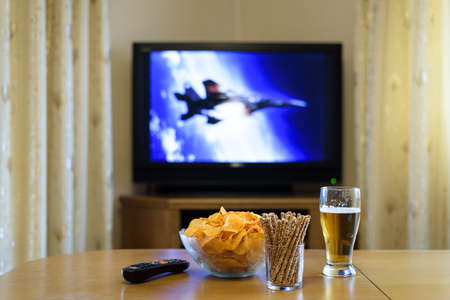TV, television watching (war movie) with snacks on tableの写真素材