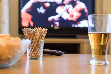 Television, TV watching (boxing match) with snacks and alcohol lying on table - stock photoの写真素材