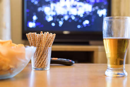 Television, TV watching (boxing match) with snacks and alcohol lying on table - stock photoの写真素材