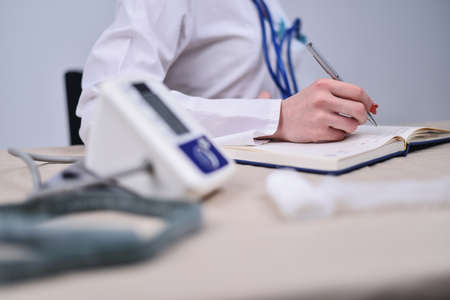 The doctor makes notes in the diaryの写真素材