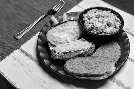Baked potatoes with mushrooms and vegetables on a plate black and white posterの写真素材
