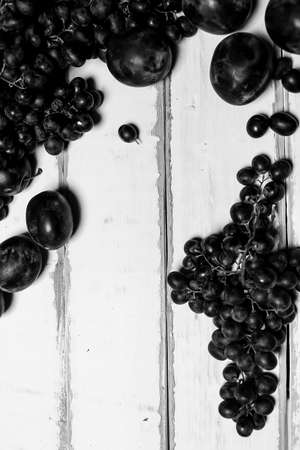 Prunes and grapes on the tableの写真素材