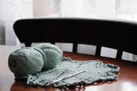 Clumps of yarn and knitting needles on the tableの写真素材