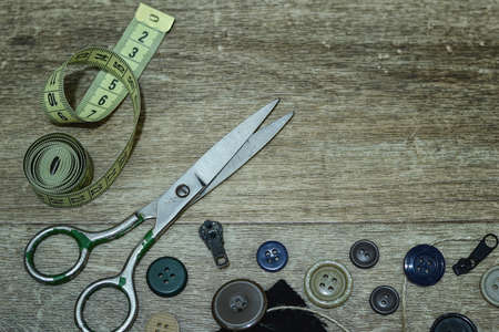 Scissors and buttons on a wooden backgroundの写真素材