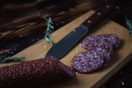 Smoked sausage on a wooden cutting boardの写真素材