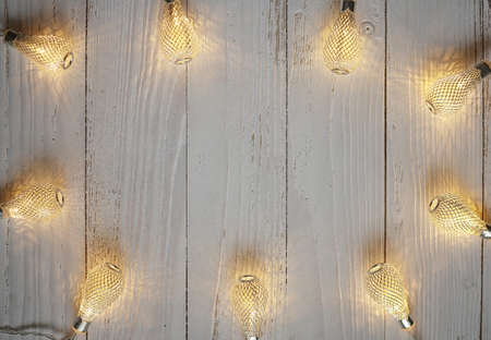 Christmas bright garlands on a wooden light backgroundの写真素材