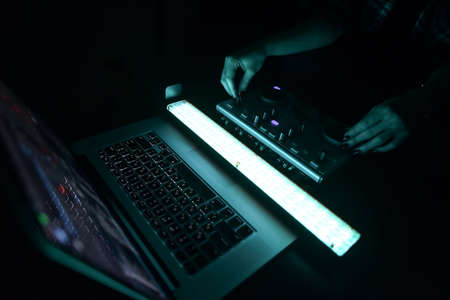 DJ mixer disco illuminated by floodlights at the club