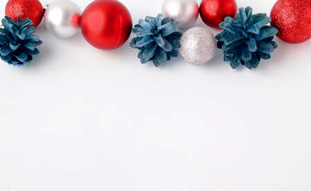 Christmas tree toys on a white background. Christmas decorations on a white surface. Balls and garland of red and silver colors on the table.の写真素材