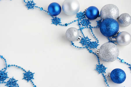 Christmas tree toys on a white background. Christmas decorations on a white surface. Balls and garland of blue and silver colors on table.の写真素材