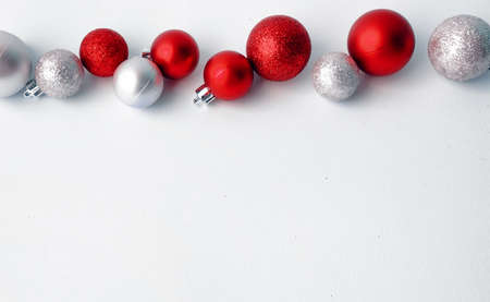 Christmas tree toys on a white background. Christmas decorations on a white surface. Balls and garland of red and silver colors on the table.の写真素材