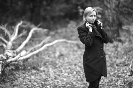 Girl walking in autumn Park. Sitting in a tree. The girl in theの写真素材