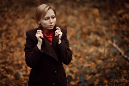 girl walking in autumn Park. Sitting in a tree. Girl in the woodの写真素材