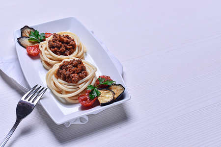 Italian pasta with meat on a plate in a cafe