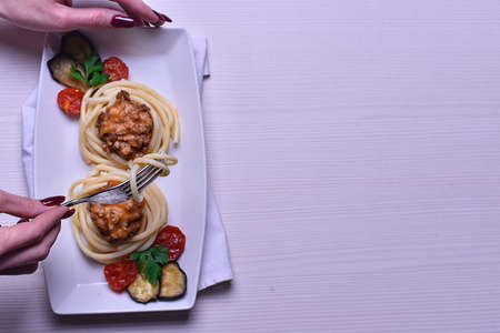 Italian pasta with meat on a plate in a cafe