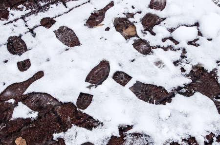 Dirty footprints in the snow in the winter. の写真素材