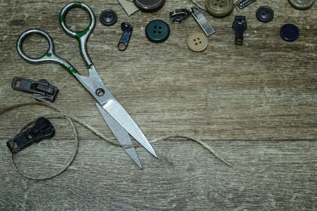 Scissors and buttons on a wooden backgroundの写真素材