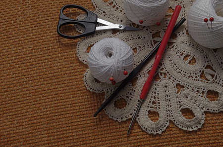 Objects for sewing. Scissors and pins. Hanks thread on mat. Pins