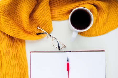 Knitted scarf and hat on the table. Warm clothes for fall and wiの写真素材