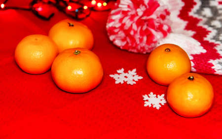 Christmas tree toys on a red napkin. Mandarins and candles on thの写真素材