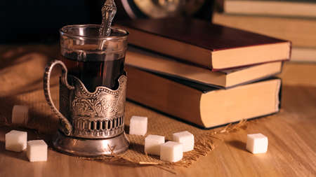 Old books and tea in the evening. A glass of drink on table. Theの写真素材