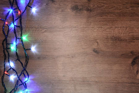 New-year electric garland on a wooden background. Bright bulbs oの写真素材