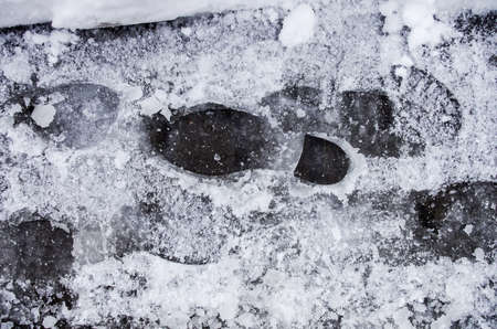 Dirty footprints in the snow winter. Track from boots on the traの写真素材