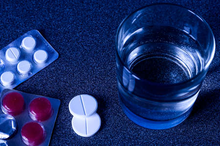The water in the glass and the medicine on the table. の写真素材