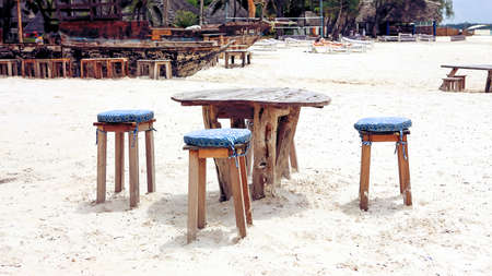 Wooden table and chairs on the beach. Furniture for lounging onの写真素材