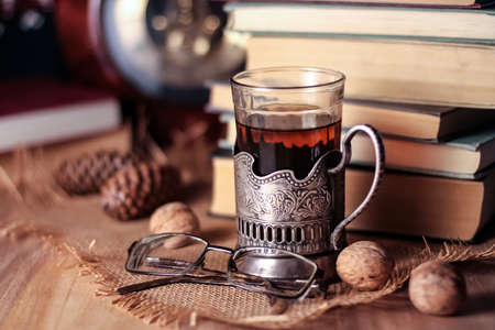 Old books and tea in the evening. A glass of drink on table. Theの写真素材