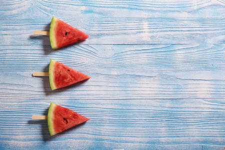 Slices of juicy red watermelon on a wooden backgroundの写真素材