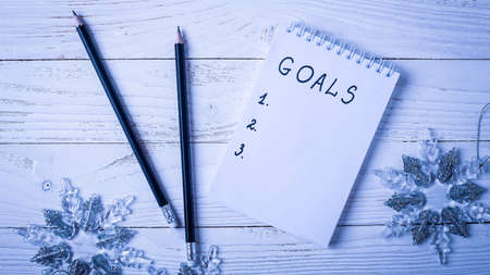 Workplace with a diary, decorations and gifts. New Year's list of gifts. の写真素材