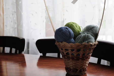 Clumps of yarn and knitting needles on the tableの写真素材
