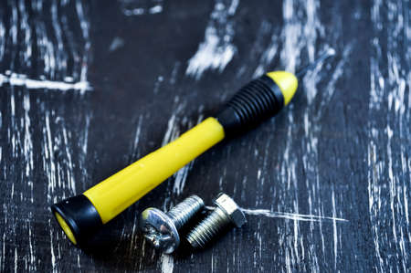 Nuts for repairs lying on a wooden table. Iron nuts and screws f