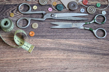 Scissors and buttons on a wooden backgroundの写真素材