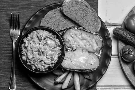 Baked potatoes with mushrooms and vegetables on a plate black and white posterの写真素材