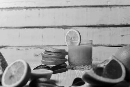 orange lying on a wooden table with leaves black and white poster