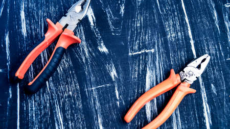Pliers for repair work lying on the table. Repair tools in the h