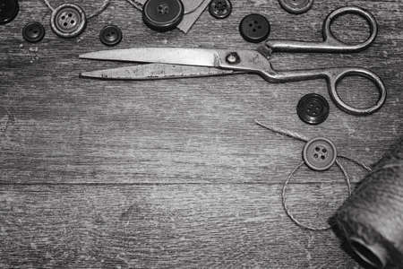 Scissors and buttons on a wooden background for embroideryの写真素材