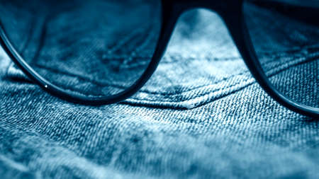 Denim clothes lying on the table with the glasses.の写真素材