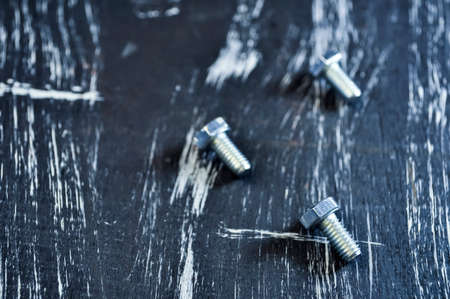Nuts for repairs lying on a wooden table. Iron nuts and screwsの写真素材