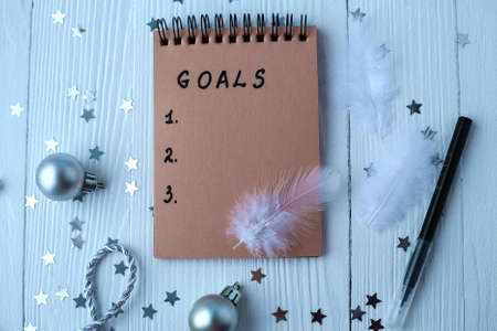 A Notepad on a wooden table near the Christmas tree. Notebook to