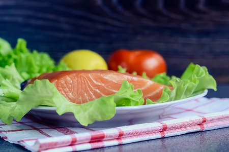 A piece of fish with vegetables on the table. Healthy food for l