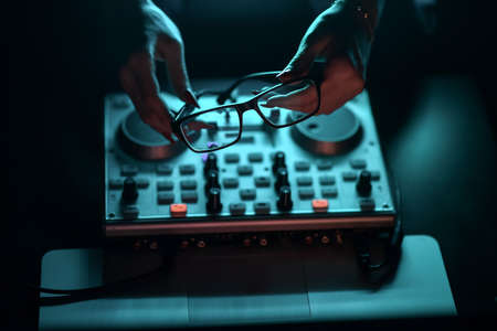 DJ mixer disco illuminated by searchlightsの写真素材