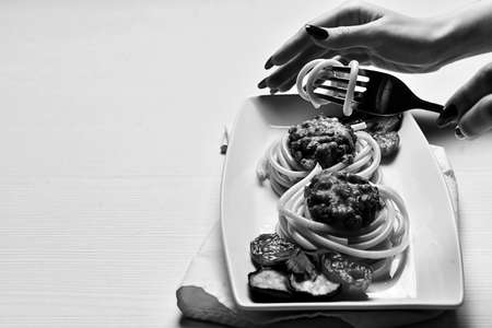 Dinner in the restaurant. Hands plates of food. Fork for eating.の写真素材