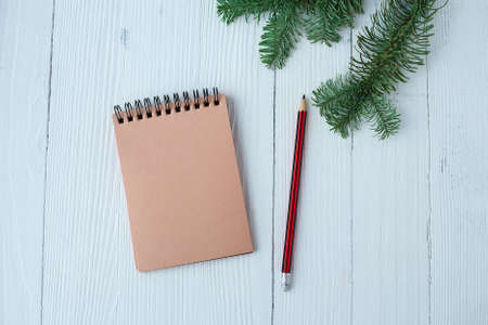 A Notepad on a wooden table near the Christmas tree. Notebookの写真素材