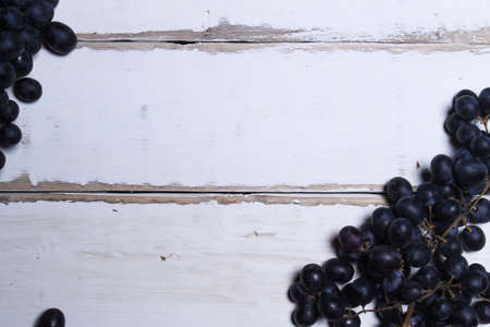 Black grapes lying on a wooden tableの写真素材