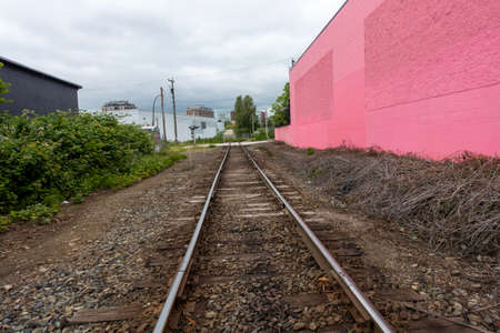 Railway tracks on the background of a pink wall in the cityの写真素材