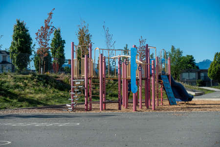 A vertical shot of a playground with a blue sky in the background
