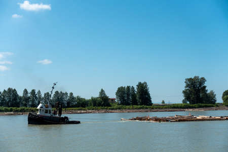 Boat on the river, blue sky and trees in the background