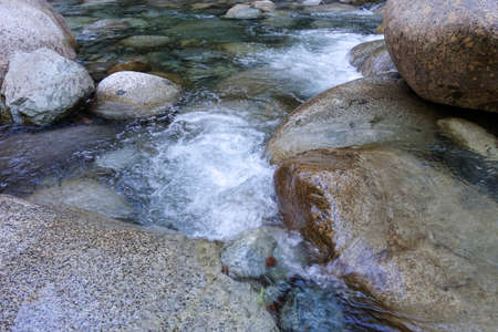 Water flowing over rocks in a stream. Close up of a mountain stream.